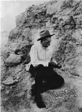 James H. Cook examining a fossil in the hills above the ranch